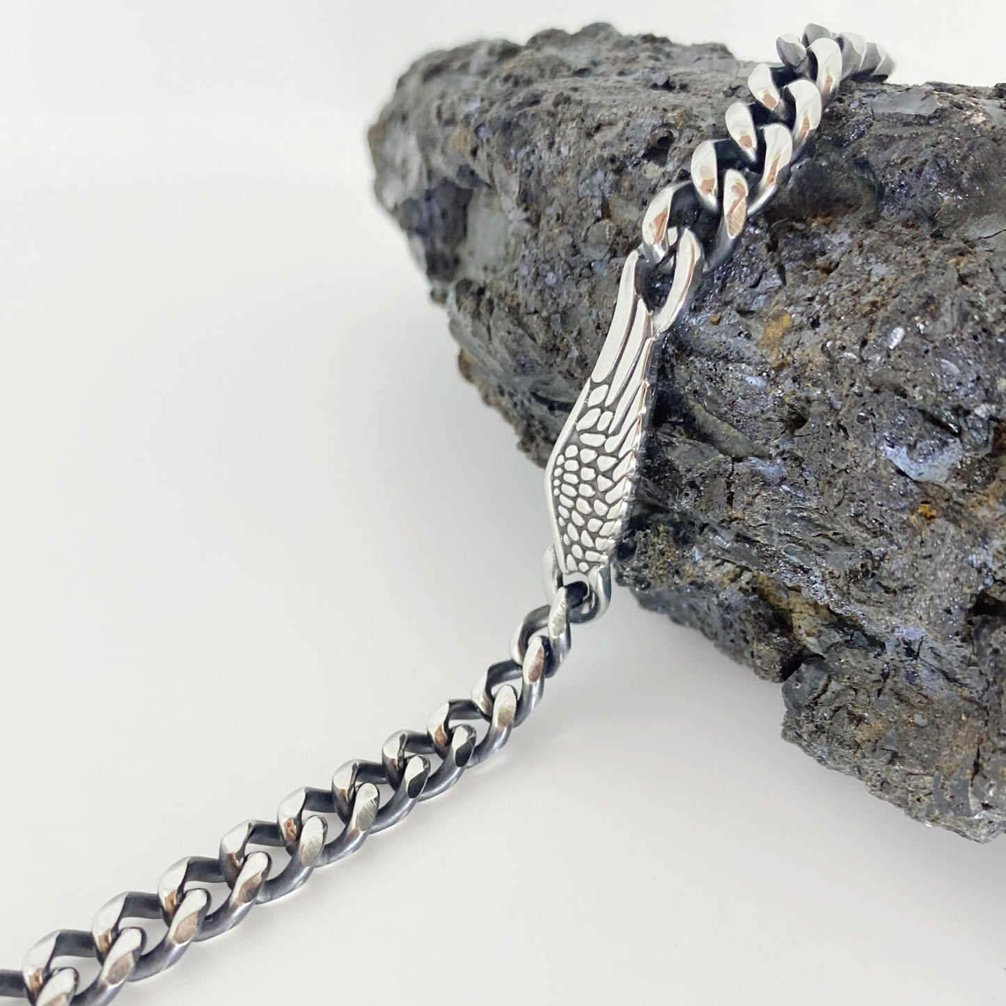 Uma pulseira poderosa e simbólica, composta por uma corrente robusta em aço inoxidável e um pingente em forma de asa, representando liberdade e proteção. Com um design marcante e detalhes meticulosos, é ideal para homens que apreciam acessórios com significado e estilo imponente.