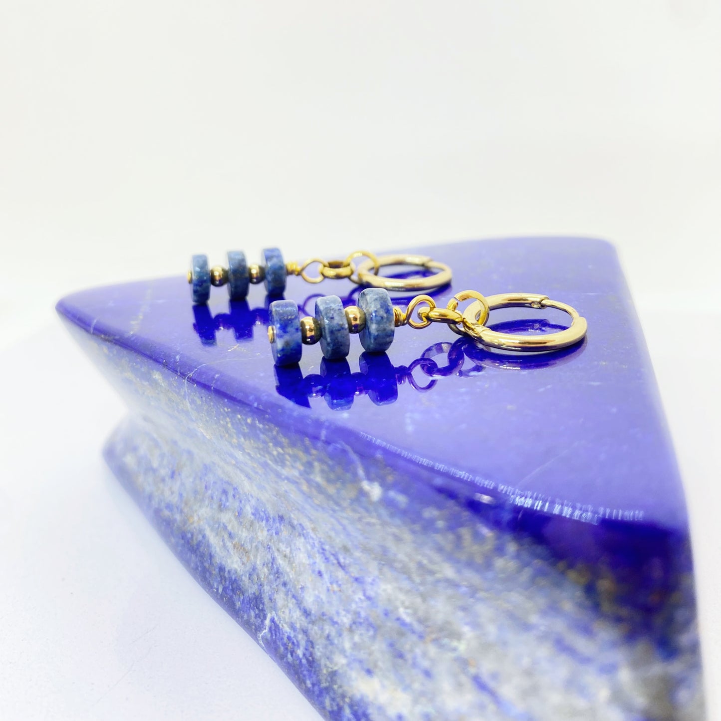 Brinco com discos de Lápis-Lazúli e detalhes dourados. Sofisticação e espiritualidade numa joia única, elegante e cheia de personalidade.